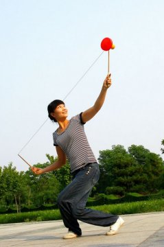 空竹を遊んでいる北京市民です。中国には「空竹」という昔からの玩具があります。日本語は「中国独楽(ゴマ) 」「空中独楽」「唐独楽」「ディアボロ」などと言われています。